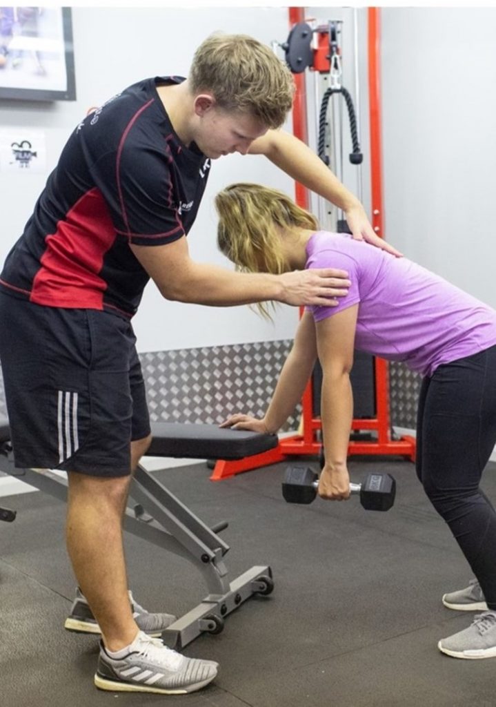 physiotherapist supervises weightlifting in biggleswade