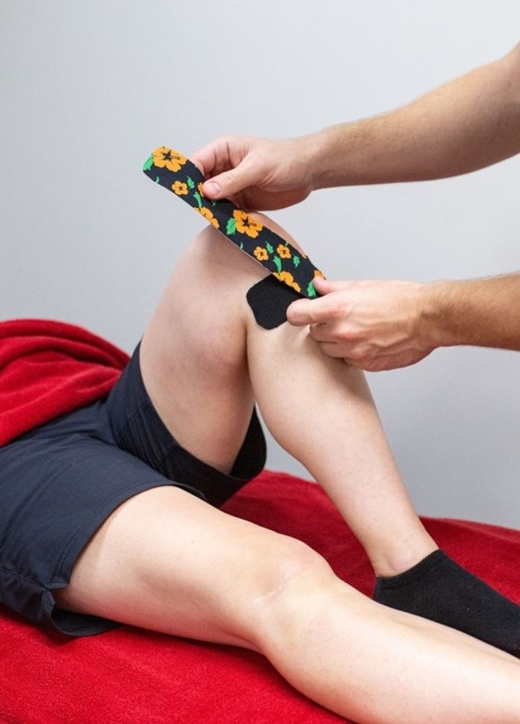 physiotherapist tapes a knee for support in biggleswade