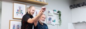 osteopath assesses a patient's shoulder